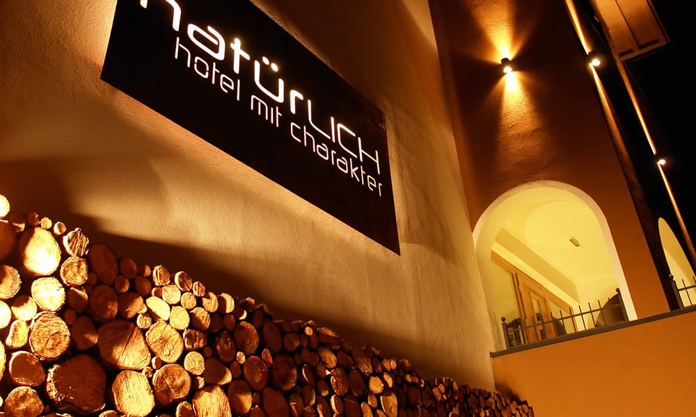 Entdecke_ Hotel Natürlich in Fiss, Tirol. Außen-Detail-Ansicht bei Nacht.