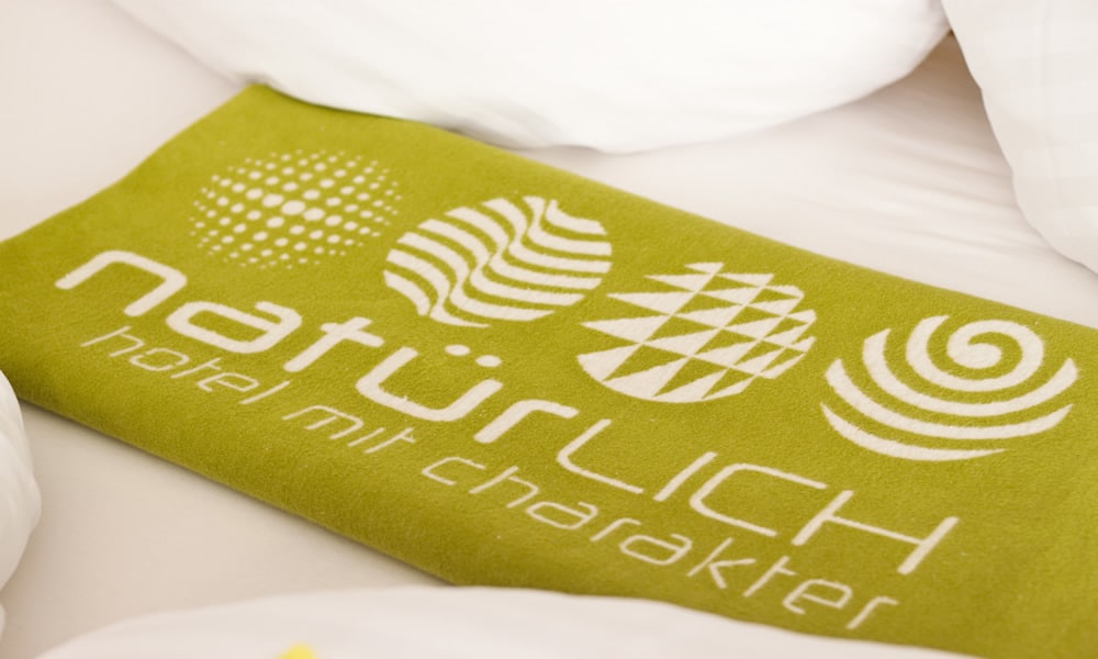 Entdecke_ Hotel Natürlich in Fiss, Tirol. Liebe zum Detail - Decke mit Logo.