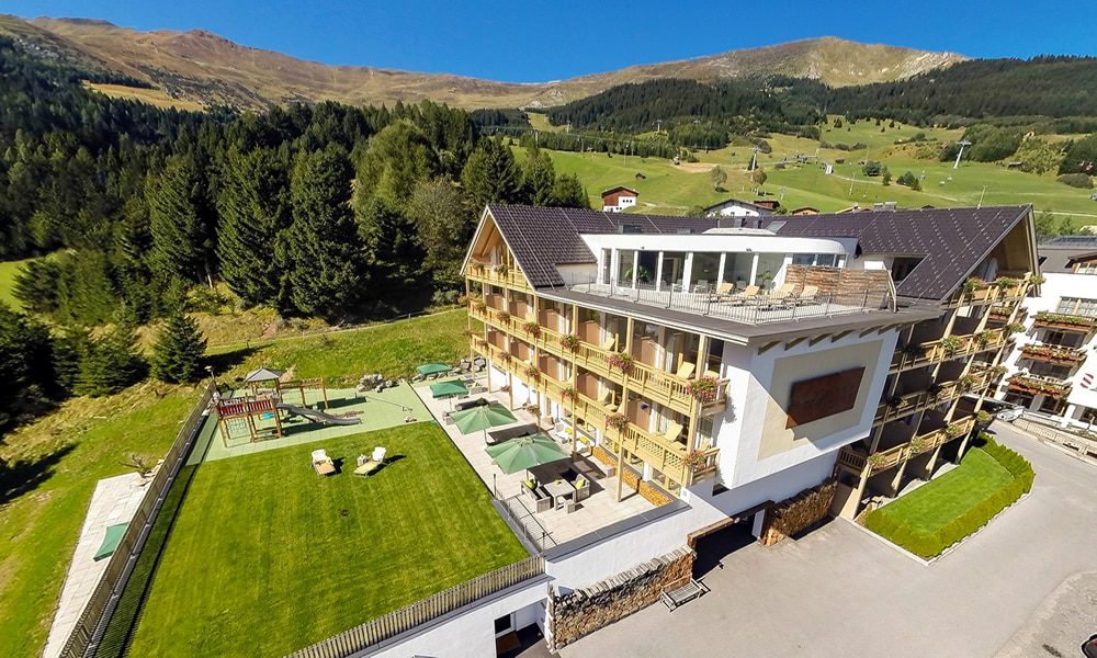 Entdecke_ Hotel Natürlich in Fiss, Tirol. Ansicht im Sommer.