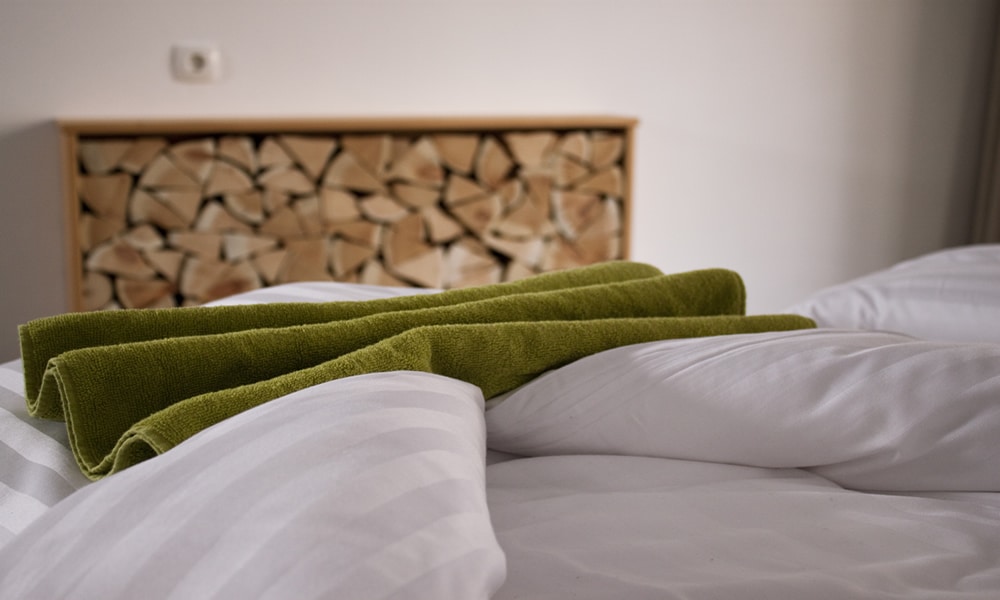 Naturbegeisterte im Natürlich. Hotel mit Charakter in Tirol - Österreich. Bett und Zirbenholzlege.