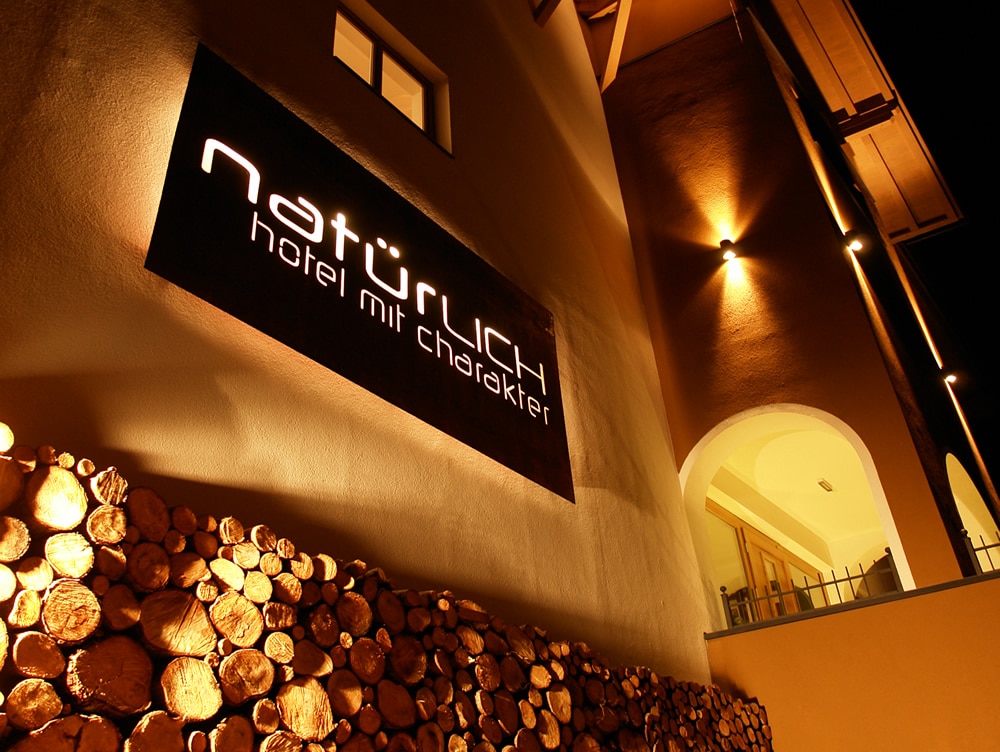Philosophie - Hotel Natürlich in Fiss, Tirol. Nacht-Außen-Ansicht Hotel Haupteingang