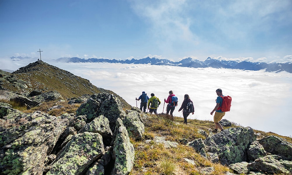 Sportbegeisterte in Serfaus-Fiss-Ladis. Menschen wandern über dem Wolkenmeer.