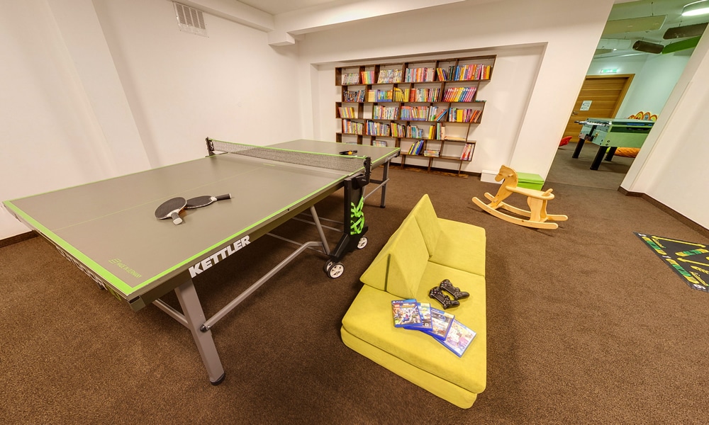 Spielzimmer - Natürlich. Hotel mit Charakter in Tirol - Österreich. Tischtennis - Bücherregal und Sitzgelegenheiten
